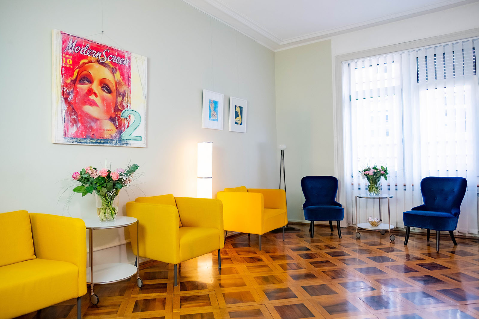 Wartezimmer der Praxis mit gelben und blauen Sesseln.